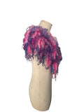Enhance your wardrobe with our Curly Caplet Statement Wool Collar. Crafted from natural wool and dyed in pink and purple, this striking fashion piece showcases curly locks from Teeswater sheep, skilfully wet and needle felted for a bold appearance. Stand out from the crowd with this exceptional accessory.
