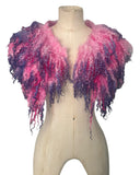 Enhance your wardrobe with our Curly Caplet Statement Wool Collar. Crafted from natural wool and dyed in pink and purple, this striking fashion piece showcases curly locks from Teeswater sheep, skilfully wet and needle felted for a bold appearance. Stand out from the crowd with this exceptional accessory.