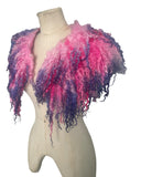 Enhance your wardrobe with our Curly Caplet Statement Wool Collar. Crafted from natural wool and dyed in pink and purple, this striking fashion piece showcases curly locks from Teeswater sheep, skilfully wet and needle felted for a bold appearance. Stand out from the crowd with this exceptional accessory.