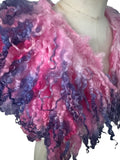 Enhance your wardrobe with our Curly Caplet Statement Wool Collar. Crafted from natural wool and dyed in pink and purple, this striking fashion piece showcases curly locks from Teeswater sheep, skilfully wet and needle felted for a bold appearance. Stand out from the crowd with this exceptional accessory.