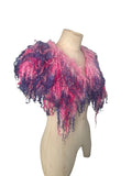Enhance your wardrobe with our Curly Caplet Statement Wool Collar. Crafted from natural wool and dyed in pink and purple, this striking fashion piece showcases curly locks from Teeswater sheep, skilfully wet and needle felted for a bold appearance. Stand out from the crowd with this exceptional accessory.