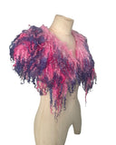 Enhance your wardrobe with our Curly Caplet Statement Wool Collar. Crafted from natural wool and dyed in pink and purple, this striking fashion piece showcases curly locks from Teeswater sheep, skilfully wet and needle felted for a bold appearance. Stand out from the crowd with this exceptional accessory.